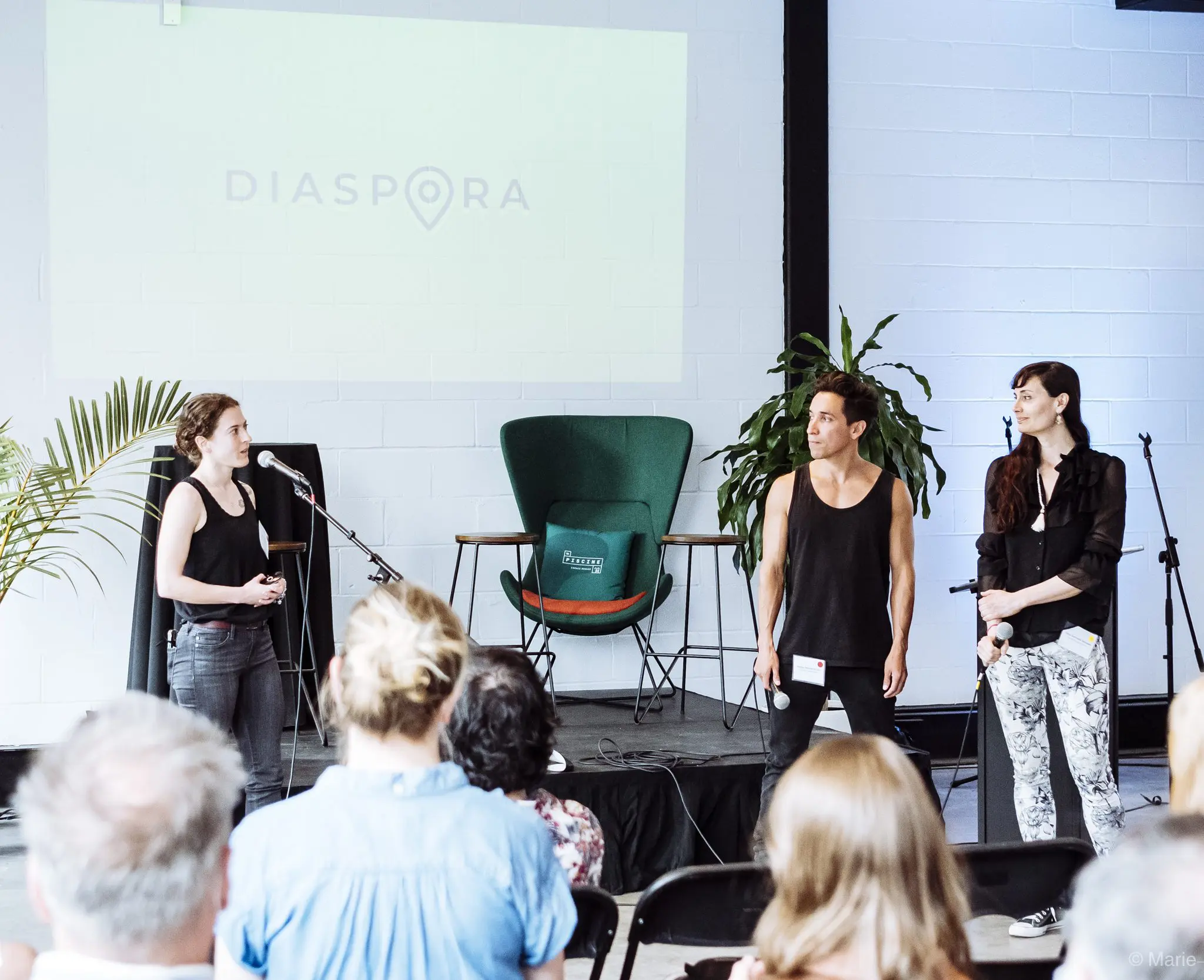 Trois personnes se tiennent sur une scène devant un public, parlant dans des microphones avec un grand écran derrière eux affichant "DIASPORA". L'événement est organisé par le laboratoire en entrepreneuriat et innovation du CRITAC, avec des plantes et du matériel audio visibles sur la scène.