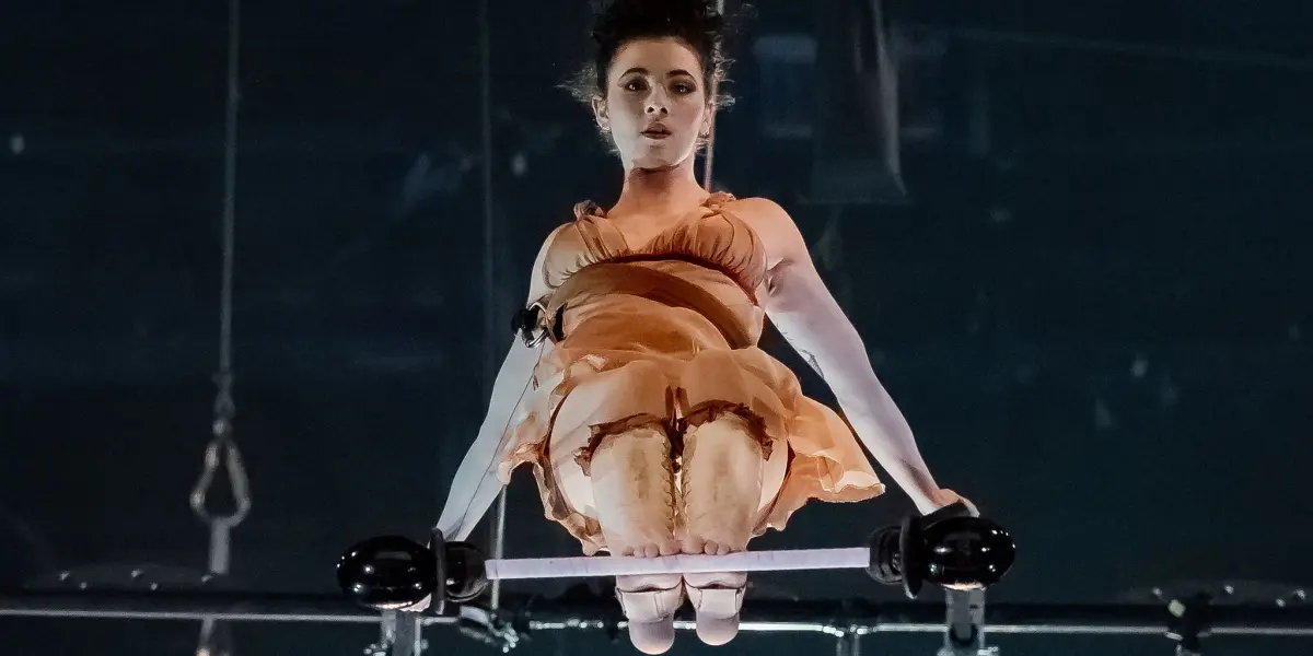 Alizé Poitreau se tient élégamment dans une robe au dessus du bar, captivant tout le monde avec son charme sans effort.