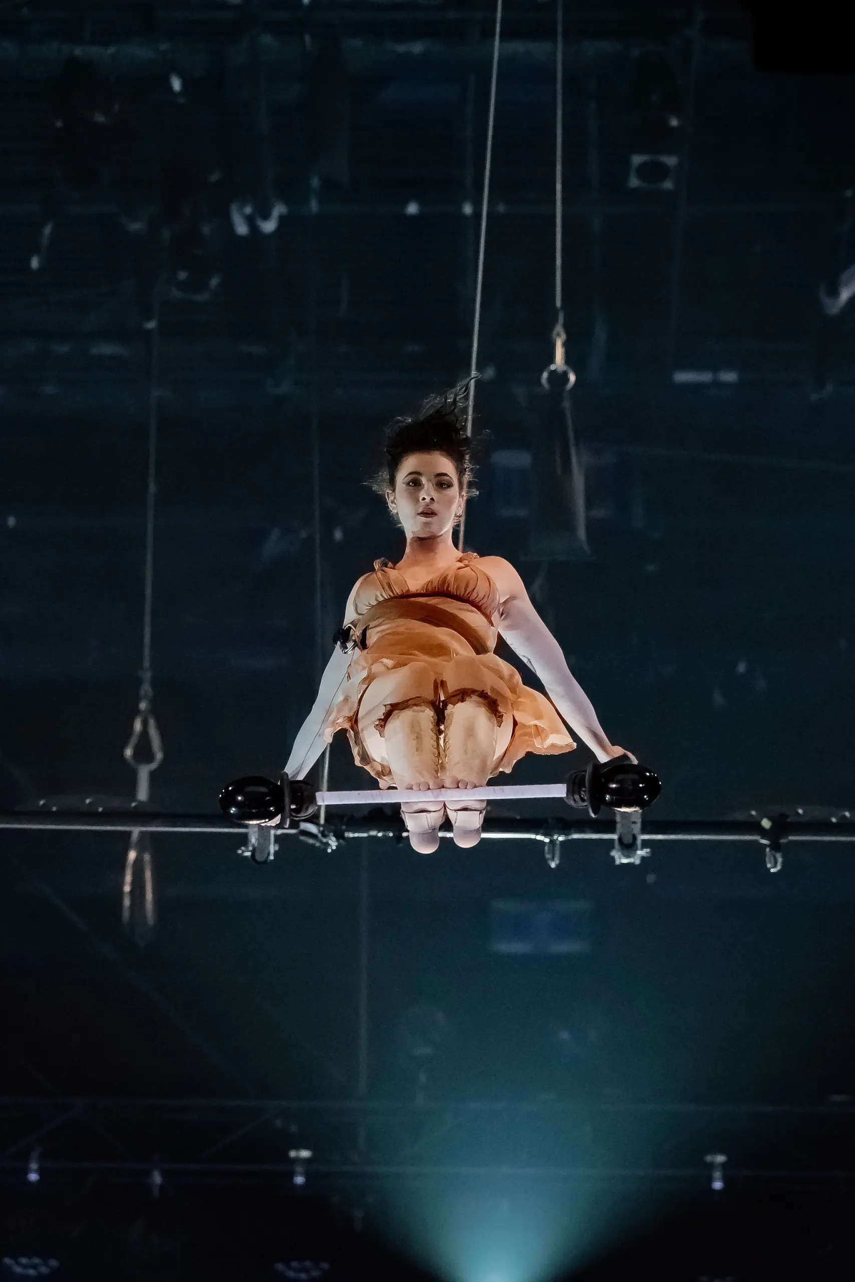 Alizé Poitreau se tient élégamment dans une robe au dessus du bar, captivant tout le monde avec son charme sans effort.