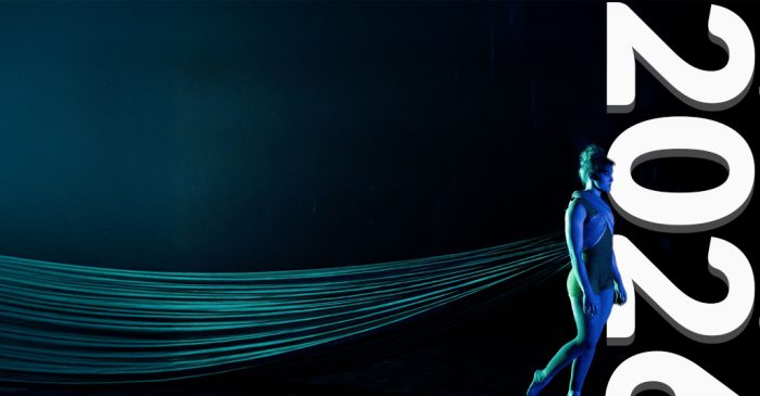 Un artiste de cirque se tient sur scène devant un tissu fluide de couleur sarcelle, tandis qu'un texte blanc en gras annonce AUDITIONS 2026 à droite, soulignant la Refonte du processus d'audition de l'ÉNC et présentant le logo de l'École nationale de cirque dans le coin inférieur gauche.