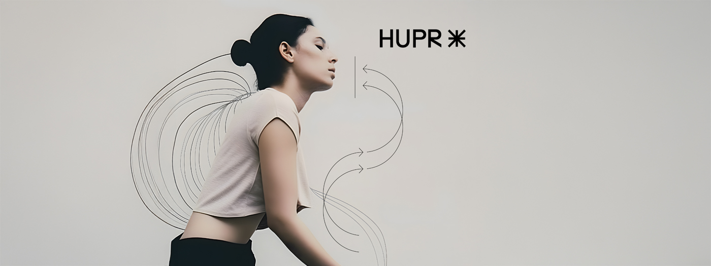 Une femme aux cheveux bruns coiffés en chignon, portant un haut clair et court, se tient debout sur un fond uni. Des flèches et des lignes noires abstraites l'entourent, ainsi que le texte "Lancement officiel : le site web de HUPR est en ligne !" et un symbole en forme d'étoile à droite.