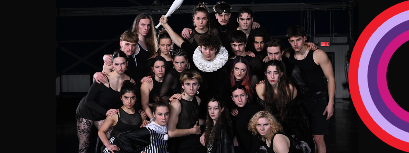 Un groupe de 23 jeunes gens vêtus pour la plupart de noir posent serrés les uns contre les autres à l'intérieur, certains avec des expressions intenses. Une personne au centre lève une massue de jonglage, suggérant un spectacle des finissants ; un graphique rond et multicolore apparaît sur le côté droit.